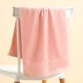 Detail of pink cotton towel with textured weave and diamond embroidery on a chair - 35*75cm / Checkered Pale Mauve Towel