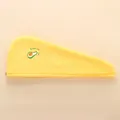 Détail d'une serviette à cheveux en molleton corail jaune avec broderie avocat et texte - Motif Avocat / Jaune