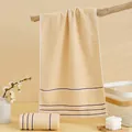 Plush cream cotton towel with dark brown stripes in a minimalist home setting - 74*34cm / Brown