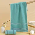 Teal cotton face towel with blue and white stripes hanging in a cozy home setting - 74*34cm / Green