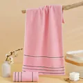 Absorbent pink cotton face towel with navy stripes in a warm home bathroom setting - 74*34cm / Pink