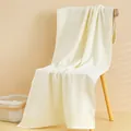 Dettaglio dell'asciugamano in cotone crema morbido con trama tessuta su sedia - 140x70cm / Bianco
