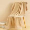 Dettaglio macro dell'asciugamano in cotone beige con trama a riccio e bordo a coste - 140x70cm / Marrone