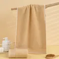 Dettaglio di asciugamani in cotone marrone morbido con riccioli assorbenti su un ramo - 75x35cm / caffè