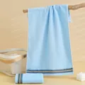 Light blue cotton towel with colorful striped border in a cozy bathroom setting - 72cmx33cm / Blue