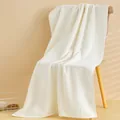 Asciugamano da bagno bianco in cotone con bordo a righe su una sedia in legno - 140x70 / Bianco