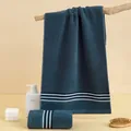 Absorbent navy blue cotton towel set with white striped edges in a home spa setting - 75x35cm / Dark Satin Navy Blue