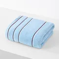 Sky blue cotton towel with dark stripes, folded on a minimalist white platform - 74cmx34cm / Blue