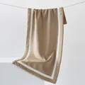 Thick khaki coral fleece towel with white striped edges hanging on a minimal display - 40x80cm / Camel