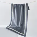 Thick grey-blue coral fleece towel with white border hanging in a minimalist setting - 40x80cm / Slate Gray