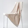 Absorbent beige cotton towel with geometric maze texture hanging on a white chair - 100cm x 50cm / Ivory