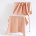 Thick peach pink cotton bath towel with soft looped texture draped on a chair - Plain Weave / Pink