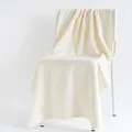 Soft cream-colored cotton bath towel draped over a white minimalist Nordic chair - Plain Weave / White