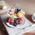 Modern white 2-tier ceramic dessert stand with fruits on a stylish wooden table - Layered White Style