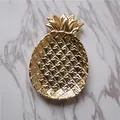 Golden pineapple ceramic jewelry tray with textured surface on marble background - Gold