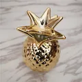 Vista superior de un adorno de piña dorada con lujosa textura metálica y acabado fino - Estilo Todo en Oro / Dorado