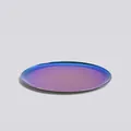 Minimalist circular titanium tray with vibrant aurora gradient finish and mirror reflection - Rainbow