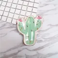 Detail of cactus-shaped ceramic jewelry tray with gold-rimmed edges and floral accents - Cactus