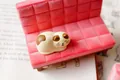 Calico cat figurine sitting on a pink velvet miniature sofa phone stand and ornament - Calico Cat