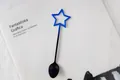 Detailaufnahme eines blau-schwarz verlaufenden Metalllöffels mit Sternform-Design - Verlauf Blau