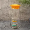 Glass water carafe with bright orange lid and colorful cartoon bus graphic design - Vintage Bus