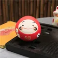 Red Daruma tumbler mascot with gold Fu character and floral rhinestones on wood base - Red Dharma