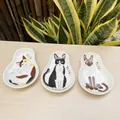 Close-up of set of 3 ceramic cat sauce dishes with cute kitten illustrations on a wood table - Cat Pattern Dishes