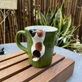 Deep green ceramic mug with vertical stripes and a 3D tricolor cat peeking over the rim - Green Calico Cat