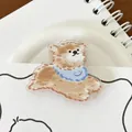 Niedliche braune Hunde-Büroklammer aus Acryl mit blauem Lätzchen auf Notizbuch - Corgi