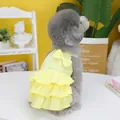 Detail view of yellow layered ruffle pet dress with a bow on a grey poodle - S / Yellow
