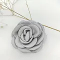 Close-up of elegant cream-white fabric camellia brooch with layered satin texture petals - Gray