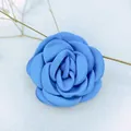 Macro view of blue fabric camellia flower with burnt edge and layered satin petals - Blue