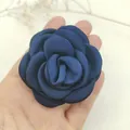Detailed view of a navy blue fabric camellia brooch with silky satin petal texture - Navy Blue