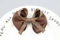 Makroaufnahme einer braunen Ripsbandschleife mit elegantem Detail aus Textband - Kaffeebraun