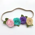 Close-up of handmade felt rose flowers and green leaves on a soft elastic baby headband - Style 3 (Light Pink/Lake Blue/Dark Purple/Beige)