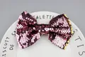 Pink purple sequined bow hair accessory with gold trim edges on a decorative plate - Pink