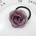 Nahaufnahme des tiefvioletten Stoff-Rosen-Haargummis auf einem weißen Keramiktablett - Altrosa