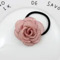 Makro-Detail eines weichen Haargummis mit rosa Stoff-Kamelienblüte für Damen und Mädchen - Altrosa