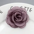 Macrodetail van handgemaakte lichtpaarse stoffen camelia met gelaagde mesh-structuur - Oudroze