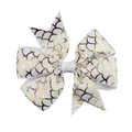 Close-up of white grosgrain ribbon hair bow with golden fish scale pattern details - White