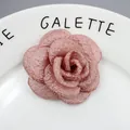 Macro-opname van handgemaakte camelia-broche in oudroze stof met organza laagjes - Oudroze