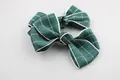 Close-up of two green checkered fabric bow clips for girls with fine texture and stitching - Dark Green