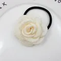 Eleganter cremefarbener Stoff-Rosen-Haargummi mit schwarzem Gummiband auf Dekoteller - Beige