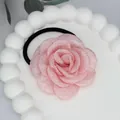 Eleganter rosa Stoff-Rosen-Haargummi mit schwarzem Gummiband auf weißem Tablett - Rosa