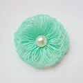 Detail of mint green woven fabric flower accessory with central faux pearl bead - Light Green