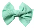 Close-up of 5 inch mint green bullet fabric bow with textured grain for DIY hair accessories - Apple Green