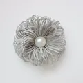 Macro detail of silver cord flower brooch with central pearl embellishment - Silver Grey