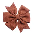 Dettaglio macro di fiocco in maglia a nido d'ape terracotta per accessori capelli bimbi - Marrone