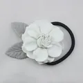 Détail d'un chouchou à fleurs avec pétales blancs, feuilles grises et élastique noir - Blanc