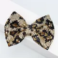 Dettaglio del fiocco con paillettes leopardate e trama glitterata in oro e nero lucido - Oro